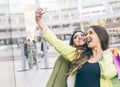 Two beautiful girls making shopping in the city center and taking a selfie with smart phone Royalty Free Stock Photo