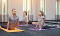 Two beautiful girls and man do yoga in the sport center and spa. Royalty Free Stock Photo