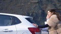 Two beautiful girls push the broken car on the road. a man sits behind the wheel