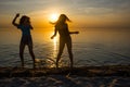 Two beautiful girls, students are dancing on the beach at sunset Royalty Free Stock Photo