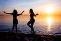 Two beautiful girls, students are dancing on the beach at sunset Royalty Free Stock Photo