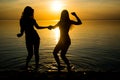 Two beautiful girls, students are dancing on the beach at sunset Royalty Free Stock Photo