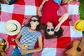 Two beautiful girls in sunglasses having fun on a picnic in the forest Top view