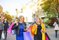 Two girls walking down the street with shopping bags, smiling and looking at the camera Royalty Free Stock Photo