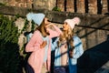 Two beautiful glamorous autumn day girls outside in the city. Gentle colors of clothing. Gossiping and jealousy. Girl Royalty Free Stock Photo