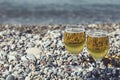 Two beautiful glass with light refreshments on the pebbles on th