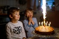 Two beautiful kids, little preschool boys celebrating birthday and blowing candles Royalty Free Stock Photo