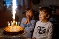 Two beautiful kids, little preschool boys celebrating birthday and blowing candles Royalty Free Stock Photo