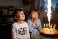 Two beautiful kids, little preschool boys celebrating birthday and blowing candles Royalty Free Stock Photo