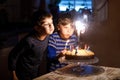 Two beautiful kids, little preschool boys celebrating birthday and blowing candles Royalty Free Stock Photo