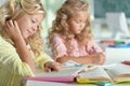 Two beautiful little girls at class read book and writing at not Royalty Free Stock Photo