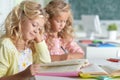 Two beautiful little girls at class read book and writing at not Royalty Free Stock Photo