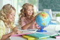 Two beautiful little girls at class reading book and looking at Royalty Free Stock Photo