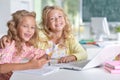 Two girls at class using laptop and writing Royalty Free Stock Photo