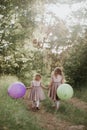 Two beautiful little girls in the summer in a park with balloons in hands. Happy girl with balloons Royalty Free Stock Photo