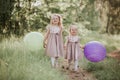 Two beautiful little girls in the summer in a park with balloons in hands. Happy girl with balloons Royalty Free Stock Photo