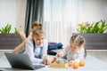 Two beautiful little sisters playing chess on a floor in living room Royalty Free Stock Photo