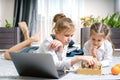 Two beautiful little sisters playing chess on a floor in living room