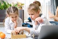 Two beautiful little sisters playing chess on a floor in living room Royalty Free Stock Photo