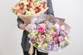 Two beautiful luxury bouquet of mixed flowers in woman hand. the work of the florist at a flower shop. A small family Royalty Free Stock Photo