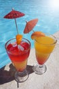 Two colorful cocktails near the pool