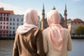 Two beautiful Muslim women wearing hijabs in European city on sunny day