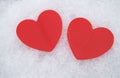 Two beautiful romantic red hearts together on a white snowy background. The concept of love and Valentine\'s Day