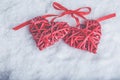 Two beautiful romantic vintage red hearts tied together with ribbon on white snow background. Love and St. Valentines Day concept Royalty Free Stock Photo