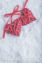 Two beautiful romantic vintage red hearts tied together with ribbon on white snow background. Love and St. Valentines Day concept Royalty Free Stock Photo