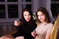 Two beautiful elegant girl in evening dresses drink champa