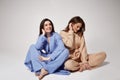 Two beautiful sexy woman friends wear casual clothes home beige and blue suit comfortable organic fashion model natural makeup