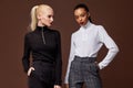 Two beautiful sexy woman long brunette blond hair glamour model wear pants and sweater work office style dress code accessory
