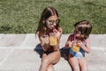 Two beautiful sister kids at the pool drinking healthy orange juice and having fun outdoors. Summertime and lifestyle concept Royalty Free Stock Photo