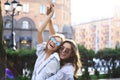 Two beautiful smiling girls in trendy summer clothes posing on street background. Models are having fun and hugging Royalty Free Stock Photo