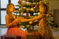 Girls Sitting on Floor Looking at Each Other in front Christmas Royalty Free Stock Photo
