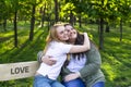 Two beautiful smiling young models sitting on the park bench and hugging sunny spring day Royalty Free Stock Photo