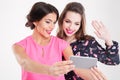 Two beautiful smiling young women making selfie using mobile phone Royalty Free Stock Photo