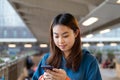 Two Beautiful stylish and smiling Young Woman Using Smartphone in Night City Street Full of Neon Light. back view Royalty Free Stock Photo