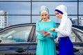 Two beautiful and successful european muslim business women entrepreneur in stylish hijab and turban holding paper Royalty Free Stock Photo