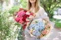 Two Beautiful summer bouquet. Arrangement with mix flowers. Young girl holding a flower arrangement with hydrangea. The Royalty Free Stock Photo