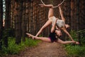 Two beautiful teen gymnasts doing exercises at the air ring in the woods Royalty Free Stock Photo