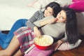 Two beautiful teenage girls eating popcorn and watching movies Royalty Free Stock Photo