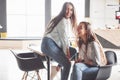 Two beautiful twin girls spend time. Sisters relaxing in a cafe and having fun together and whispering Royalty Free Stock Photo