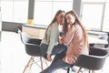 Two beautiful twin girls spend time. Sisters relaxing in a cafe and having fun together and whispering Royalty Free Stock Photo