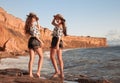 Two beautiful twins girl in straw hat having fun on the beach enjoying life, summer sunset outdoor portrait. People Girlfriend Royalty Free Stock Photo