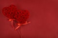 Two beautiful velvet hearts on red textured paper