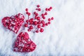 Two beautiful vintage red hearts with mistletoe berries on a white snow background. Christmas, love and St. Valentines Day concept Royalty Free Stock Photo