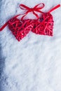 Two beautiful vintage red hearts tied together with a ribbon on a white snow background. Love and St. Valentines Day concept. Royalty Free Stock Photo