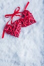 Two beautiful vintage red hearts tied together with a ribbon on a white snow background. Love and St. Valentines Day concept. Royalty Free Stock Photo