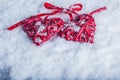 Two beautiful vintage red hearts tied together with a ribbon on a white snow background. Love and St. Valentines Day concept. Royalty Free Stock Photo